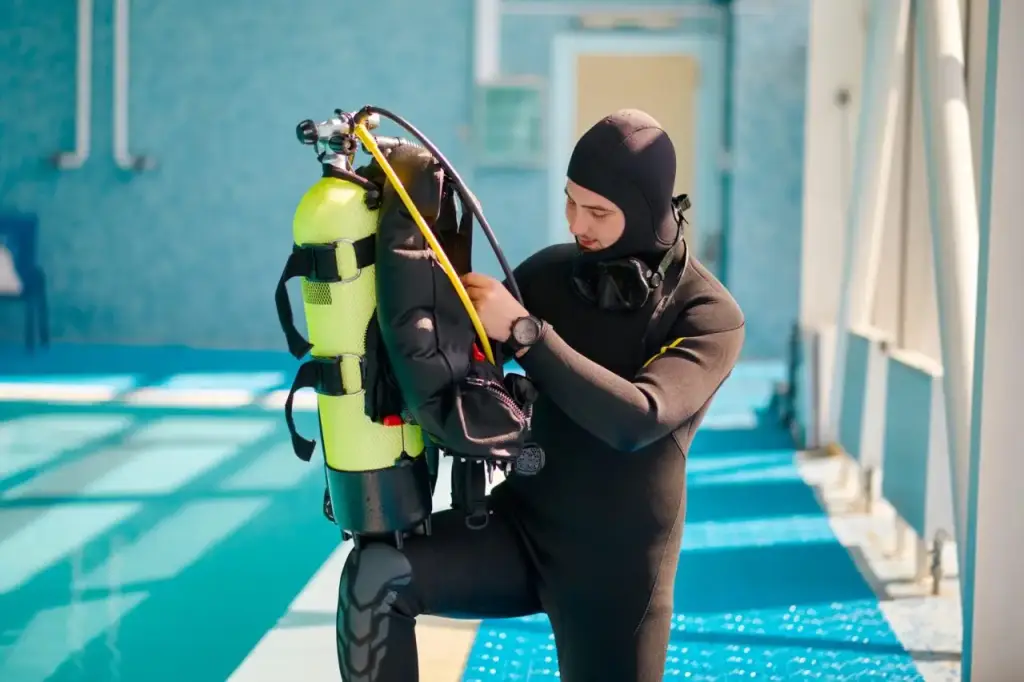 male-diver-puts-on-oxygen-tank-diving-school.jpg
